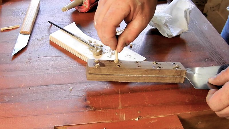 inserting wooden pins through the handle